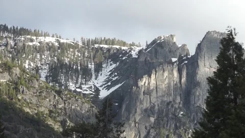 Setting sun shining on snow covered slopes in Yosemite National Park Stock Footage 241194106