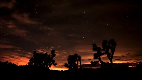Setting sun into shooting stars at the desert escape of Joshua Tree National Stock Footage