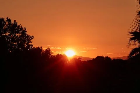 Setting Sun Sinking behind the Mountain Stock Photos