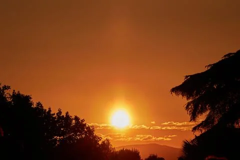 Setting Sun Sinking behind the Mountain Stock Photos