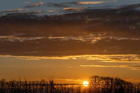 The setting sun sinks below the horizon. Foto stock