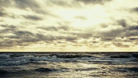 The setting sun through the clouds illuminates the ocean Stock Footage 82320517