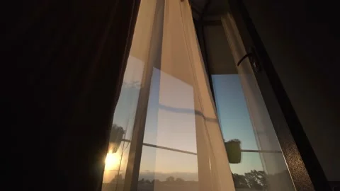 In setting sun, transparent fluttering curtain in room develops by window 스톡 동영상 204996868
