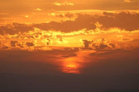 Setting Sun under the clouds. Amazing Sunset incredible sky Stock Photos