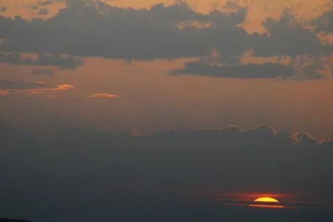 Setting Sun under the clouds Stock Photos