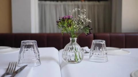 Setting a table with flowers and glassware in a restaurant Stock Footage 340245288