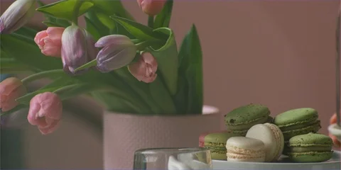 Setting table flowers and macaroon sweets in daylight Stock Footage 106220665