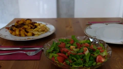 Setting the Table for a Meal: Placing a Plate of Chicken and Potatoes on a Dinin Stock Footage 274885853