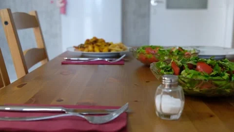 Setting the Table for a Meal: Placing a Plate of Chicken and Potatoes on a Dinin Stock Footage 274895042
