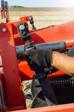 Setting up the tillage unit by the tractor driver Foto stock