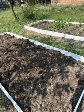 Setting up two high raised beds with wooden base. Stock Photos