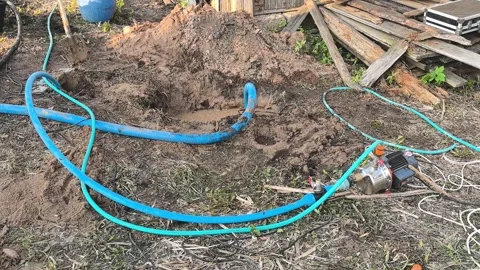 Setting up a water pump for irrigation in a garden during the afternoon in a rur Stock Footage 336127146