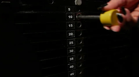 Setting the weights at a leg press machine at gym Stock Footage 48444424