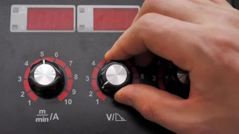 Setting up a welding machine, a man turns the regulator of the device Stock Footage 297817070