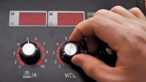 Setting up a welding machine, a man turns the regulator of the device Stock Footage 297817246