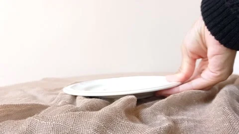 Setting a white plate on a brown table Stock Footage 146249282