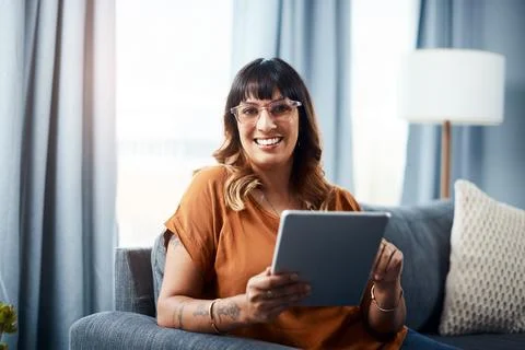 Settle down with some entertainment. a young woman using a digital tablet while Foto stock