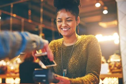 Settle your bill the effortless way. a waitress accepting a NFC payment from a Foto stock