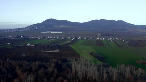 A settlement below the hill surrounded by agricultural fields Stock Footage 146010423