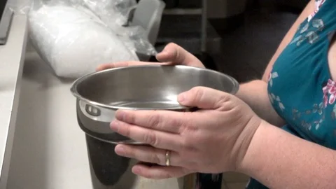 Settling and sorting items in a metal bucket in the kitchen Stock Footage 100437478