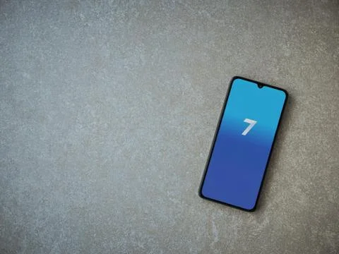 Seven app launch screen with logo on the display of a black mobile smartphone Stock Photos