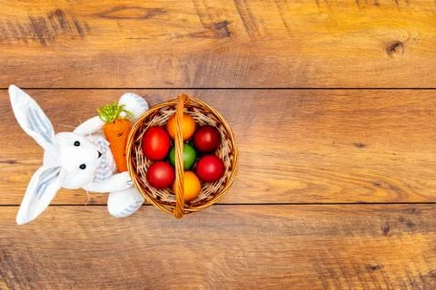 Seven colourful Easter eggs in the basket and Easter bunny wooden background Stock Photos