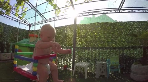 Seven-month toddler for the first time enjoys swinging Stock Footage 64868063