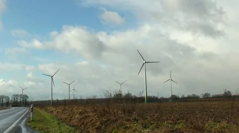 Seven rotating wind power generators in green landscape Stock Footage 21008646
