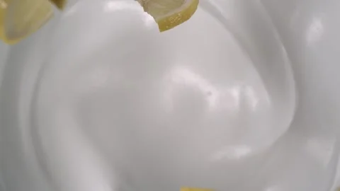 Seven of sliced lemon fall on well crafted fresh yogurt Stock Footage 161526494