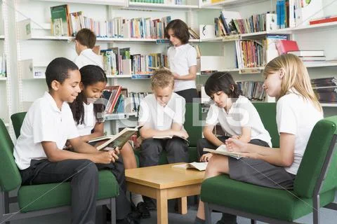 Seven students in library reading books Stock Photos
