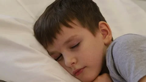 A seven-year-old boy falls asleep passionately on his bed on a pillow. Stock Footage 170308683