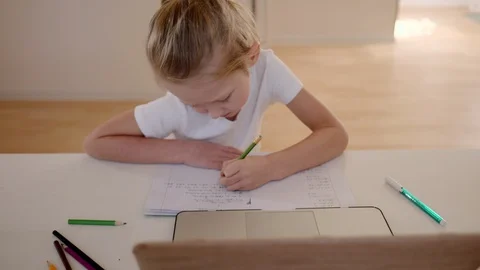 Seven-year-old boy in lockdown sitting at a table engaged in online at school, p Stock Footage 128082153