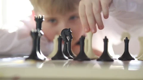 Seven-year-old boy playing chess Stock Footage 73336231