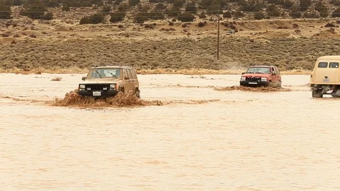 Several 4x4s Splashing Through Mud - Shallow Depth of Field Stock Footage 107074387