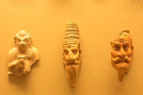 Several ancient head casts are suspended on the surface of a pink shade Stock Photos