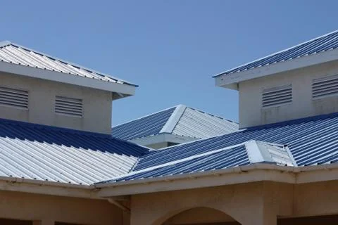 Several angled rooftops with blue siding in the sun Foto stock