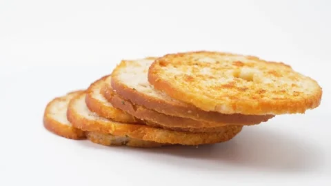 Several baked bread slices arranged in a fan shape rotate gently on a white 動画素材 325091666