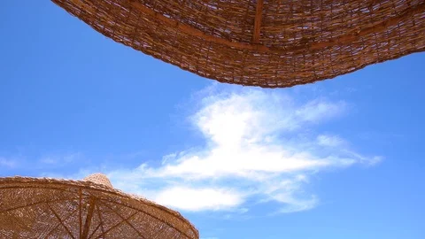 Several beach sun umbrellas isolated on sunny blue sky background Stock Footage 111423416