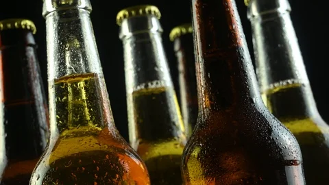 Several beer bottles clutter on a black background Stock Footage 124547683