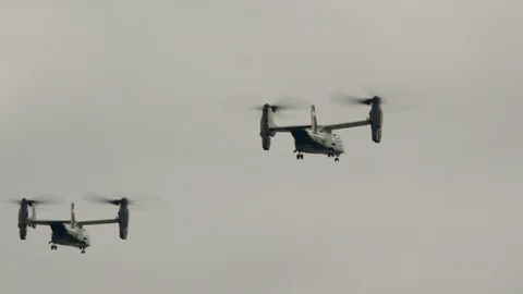 Several bell Boeing V-22 Osprey helicopters fly over the beautiful ocean coast. Stock Footage 106328562