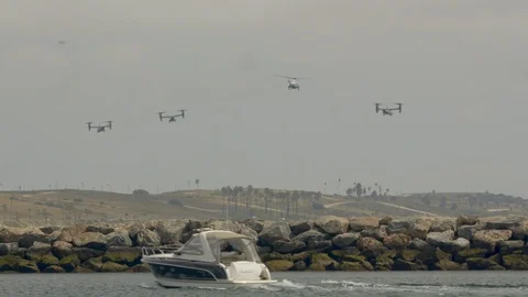 Several bell Boeing V-22 Osprey helicopters fly over the beautiful ocean coast. Stock Footage 106329523
