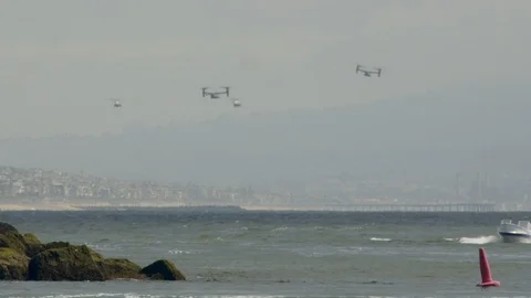 Several bell Boeing V-22 Osprey helicopters fly over the beautiful ocean coast. Stock Footage 106337189