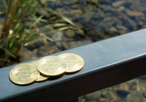 Several bitcoins cuddle on the railing on the deck of the yacht. Ocean. Summe Stock Photos