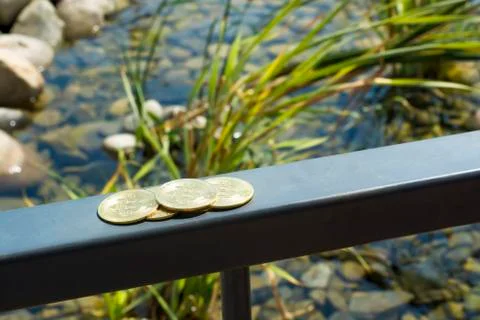 Several bitcoins cuddle on the railing on the deck of the yacht. Ocean. Stone Stock Photos