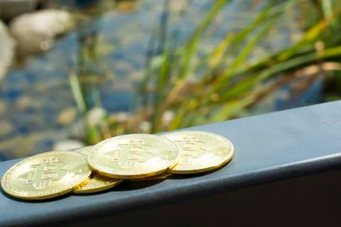 Several bitcoins cuddle on the railing on the deck of the yacht. Summer. Ocea Stock Photos