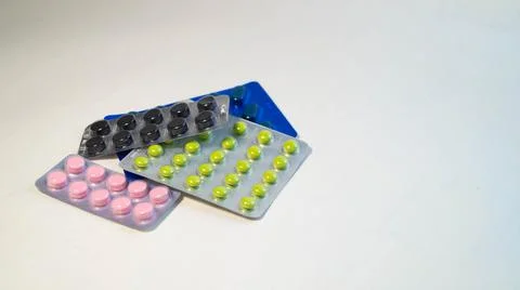 Several blisters with different tablets close-up on a white background Stock Photos