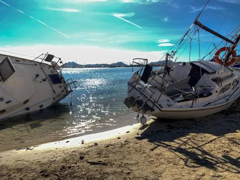 Several boats stranded on the beach after a storm. On a sunny day with few cl Stock Photos