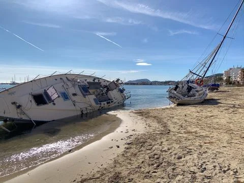 Several boats stranded on the beach after a storm. On a sunny day with few cl Stock Photos