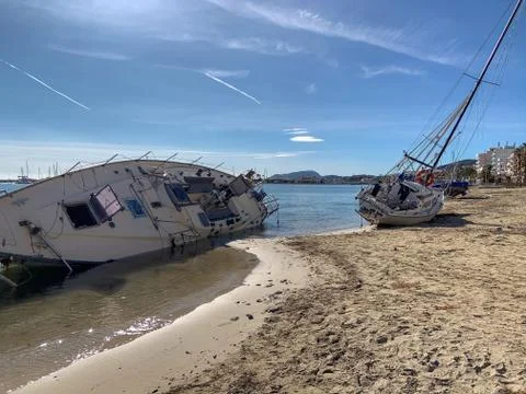 Several boats stranded on the beach after a storm. On a sunny day with few cl Stock Photos