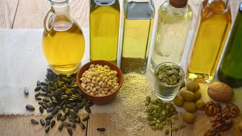 Several bottles of different oil stand on a wooden table Stock Footage 121971667